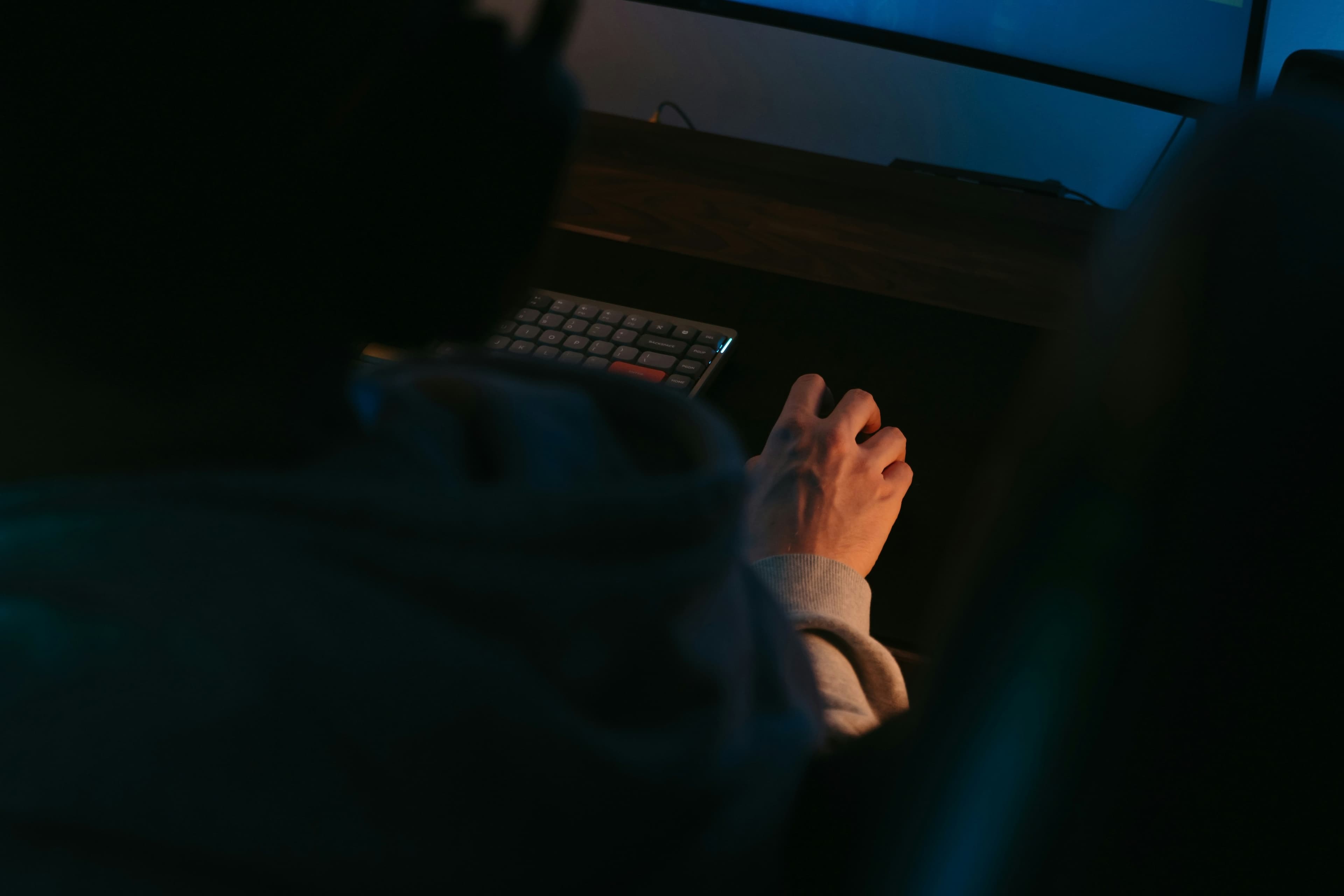 Security analyst at a desk reviewing threat intelligence on multiple monitors